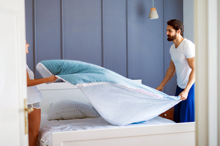 Durch Ausschütteln der Bettdecke können Symptome einer Hausstauballergie hervorgerufen werden.